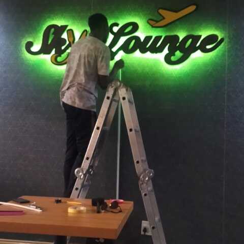 Illuminated lounge wall sign during installation