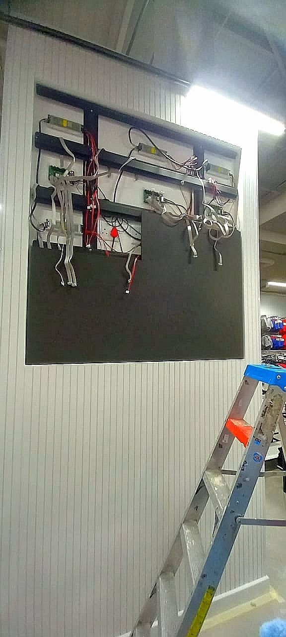 Technician installing a digital display behind a retail counter