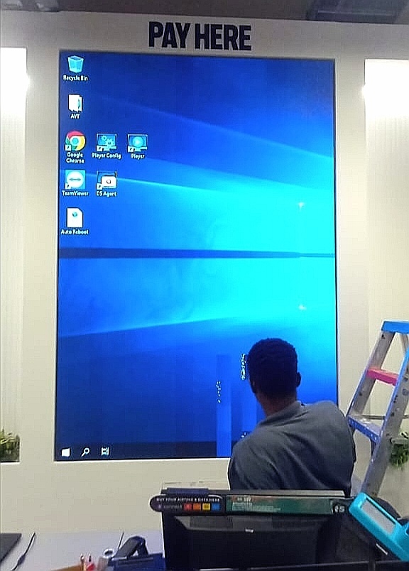 Technician testing a Pay Here digital screen